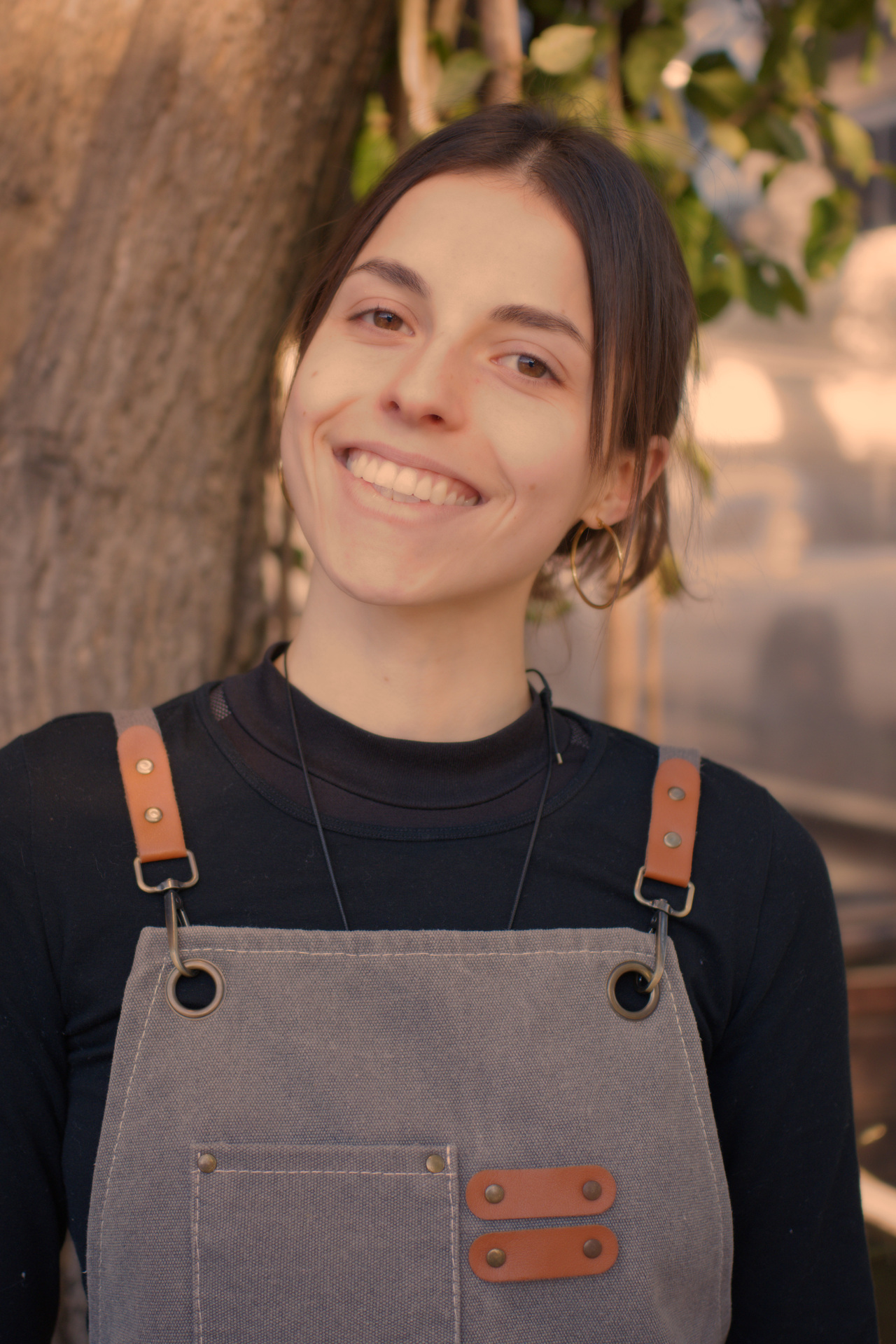 Emilia, referente de salón de La Birra, viste el delantal de servicio en el patio
