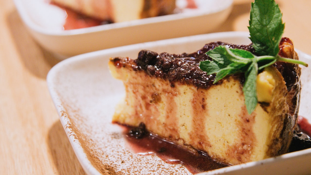 Una porción de torta vasca con frutos rojos